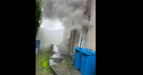 Huge fire erupts in Glasgow property as smoke billows out of front door