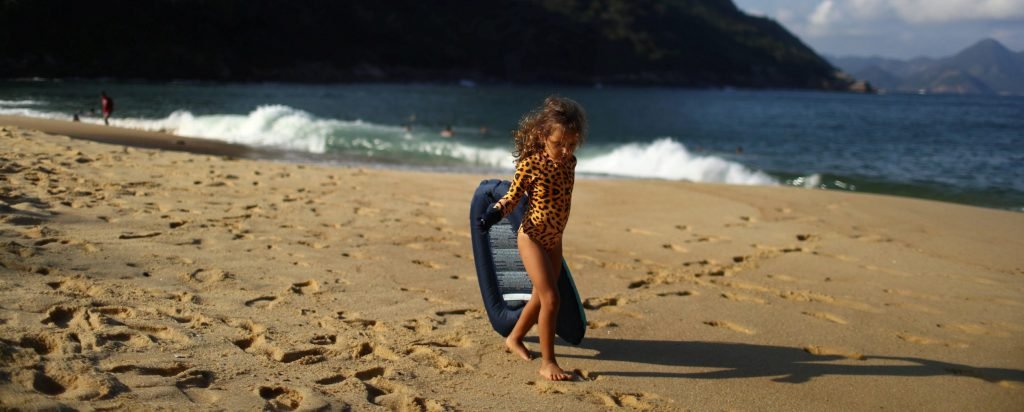 In Rio, a 4-year-old girl clears plastic waste from the ocean