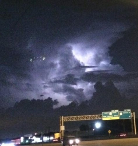 Oval Shaped UFO Spotted Hovering Over Houston Sky During Rain Storm