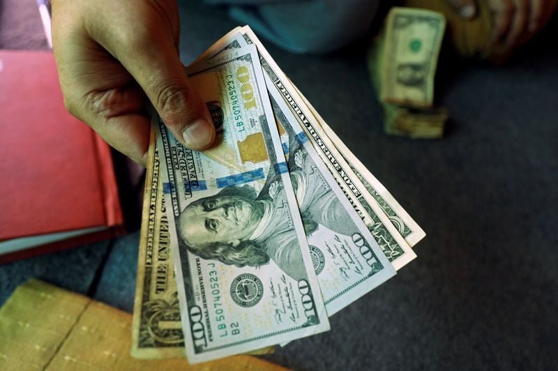 Dollar near two-week lows as rate-hike bets recede, embattled yen in focus