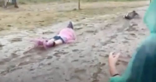 Festival goers slide in rivers of mud as torrential rain ruins event's comeback