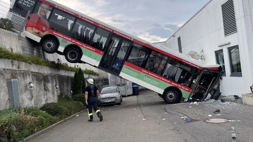 Bus stürzt nach Crash gegen Discounter