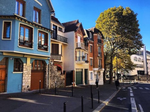 Dans quel quartier de Paris se trouve ce village pittoresque avec maisons colorées et rues pavées ?