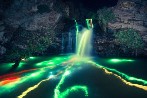 Colorful Long Exposure Photos of Glow Sticks Dropped Into Waterfalls