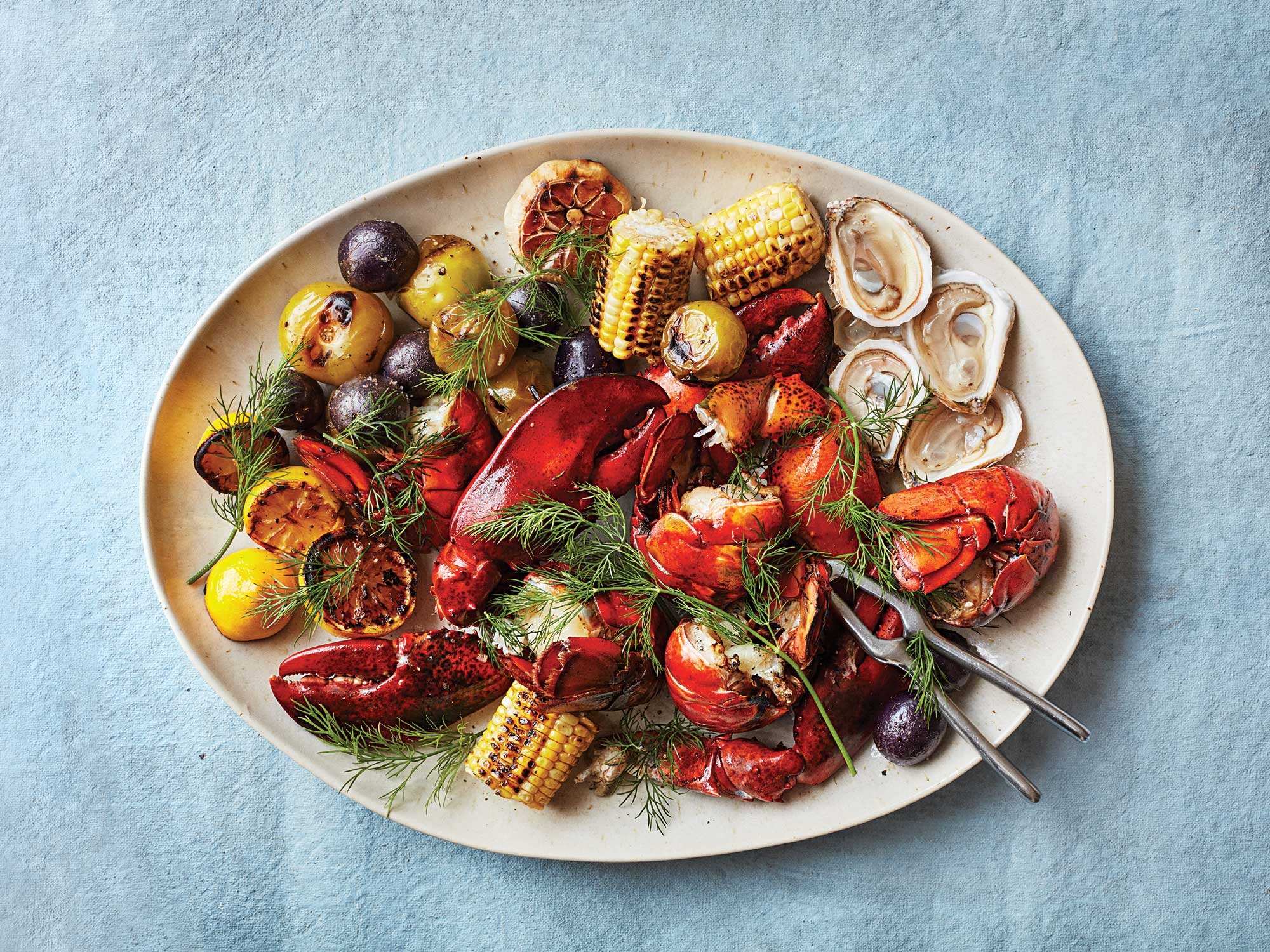 Coal-Grilled Lobsters with Charred Corn, Tomatillos, and Blue Potatoes
