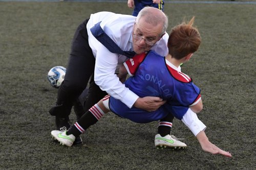 Australian prime minister Scott Morrison rugby tackles child during football match