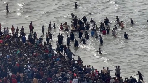 Menschen ziehen Hilfsgüter aus dem Meer 