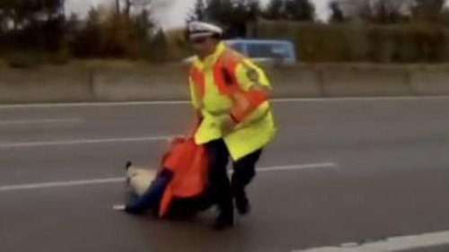 "Ab hinter die Leitplanke": Klima-Aktivistin will sich auf Autobahn festkleben, Polizist zerrt sie weg