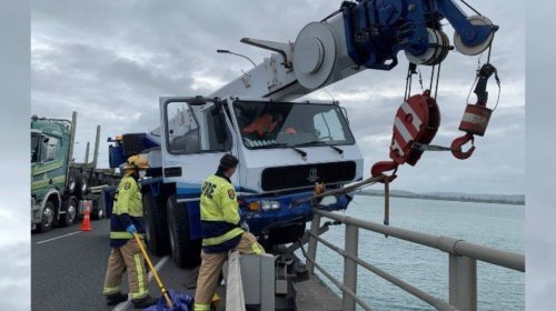 Crane truck nearly careens into Tauranga Harbour, saved by bridge railing