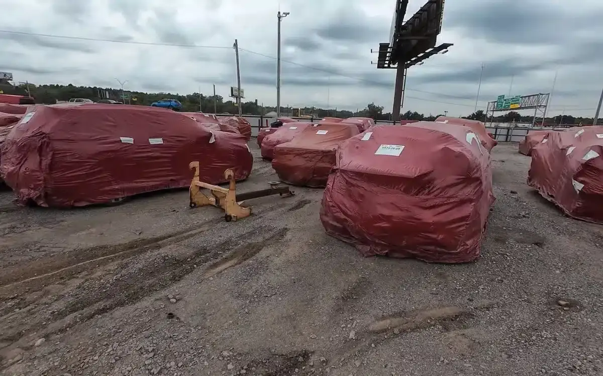 Many cars wrapped in red plastic bags were found in a yard hiding