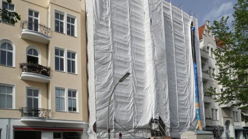 Umkämpftes Hostel in Berlins City West: Hinter der Plane wird die knallbunte Kunst des „Happy Go Lucky“ weggeklopft