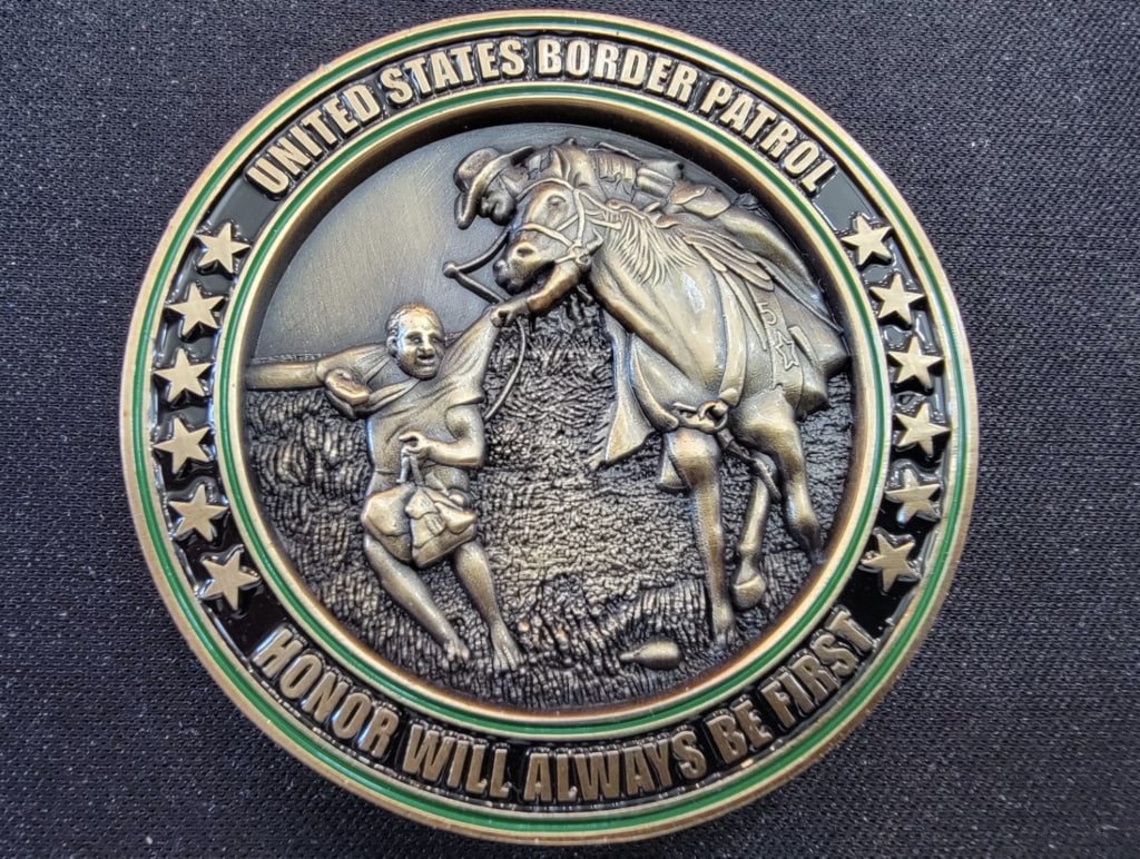 Collectible coin showing border agent grabbing Haitian immigrant under investigation by feds