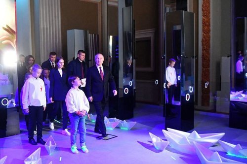 Putin greets kids, views 'nuclear button' as re-election bid nears