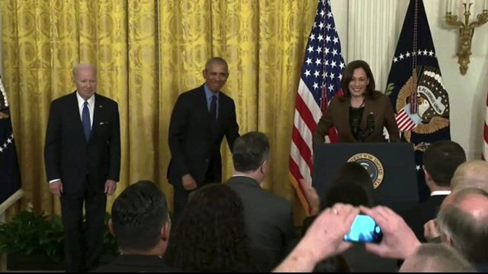 Former President Obama receives a standing ovation upon his first official return to the White House since 2017.