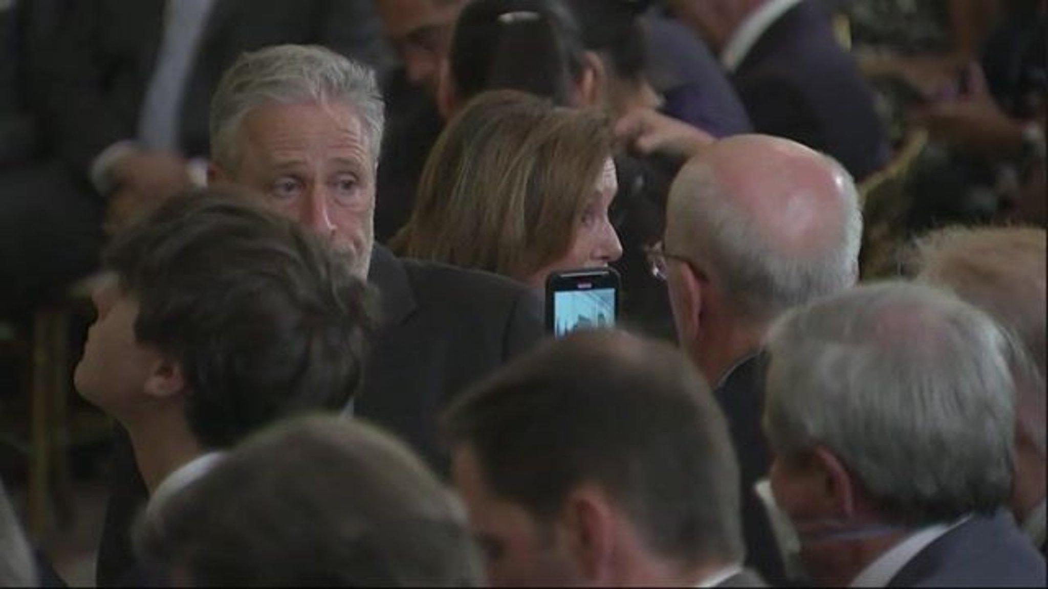 Jon Stewart seems to be in good spirits sitting front row ahead of President Biden signing the PACT Act.