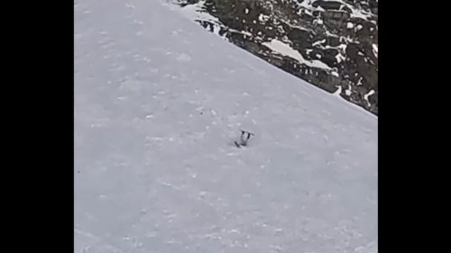 Snowboarder tumbles like a rag doll down extremely steep slope