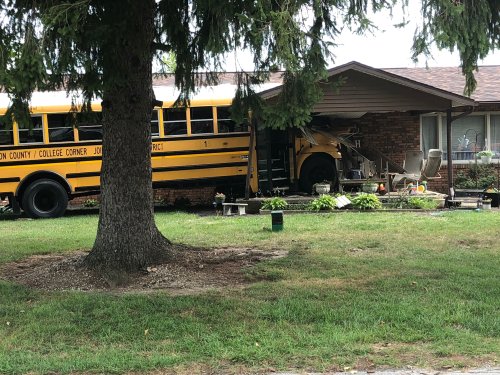 School bus with over 30 students on-board crashes into College Corner home; Driver injured