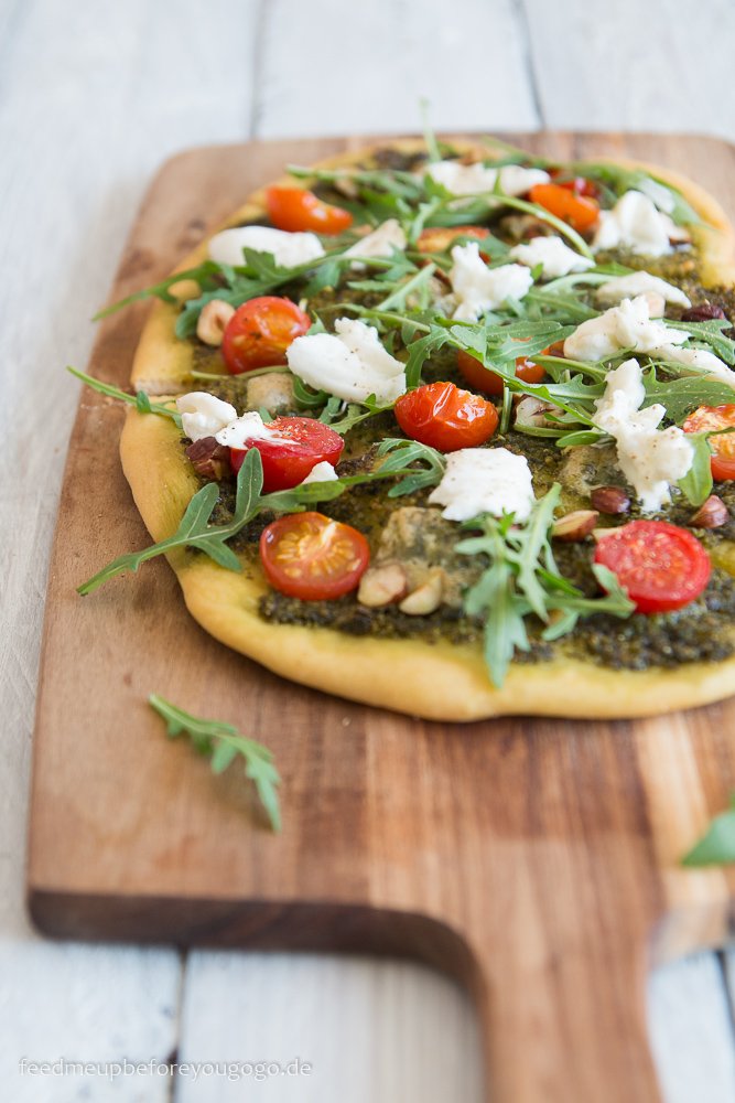 Bärlauch-Pizza mit Tomaten, Rucola, Burrata und Haselnüssen