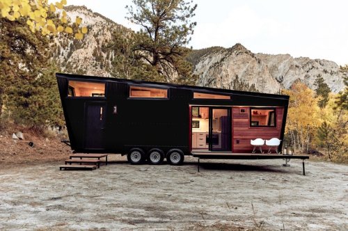 This tiny home features a bedroom loft and fold-out deck to balance comfort with adventure!