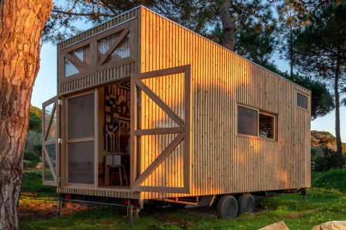 This farmhouse style tiny home is outfitted with solar panels and rainwater collection for off-grid living