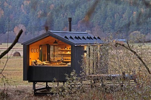A black-clad tiny home rises above the ground on a metal frame - Yanko Design
